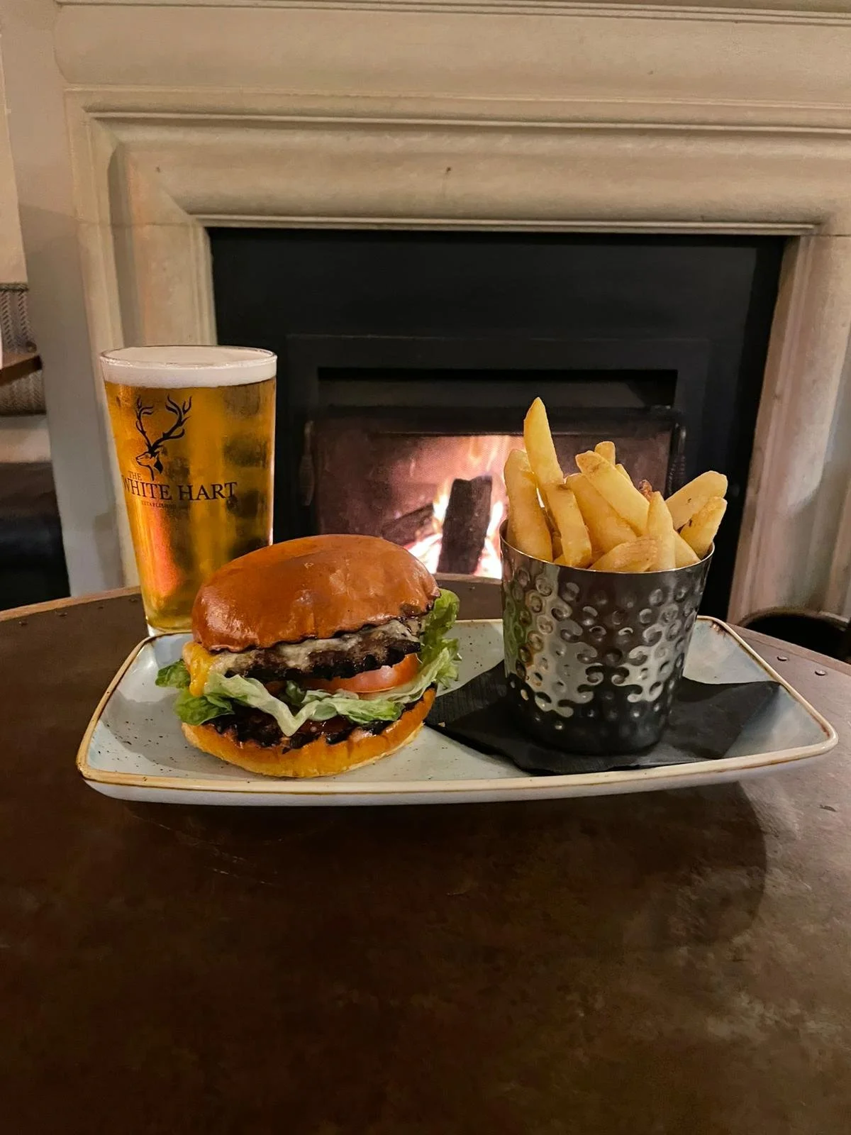 A burger, chips and a pint beside the fire at The White Hart